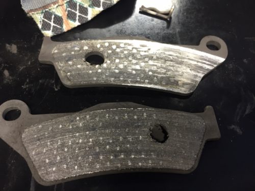 customer's brake pads that have been worn down to bare metal at Oz-racing's workshop